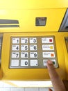 Hand finger entering on pin pad of ATM pass code business finance