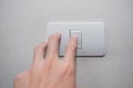 Hand with finger on light switch turn on turn off lights. Royalty Free Stock Photo