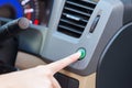 Hand finger press button eco mode inside car.