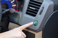 Hand finger press button eco mode inside car. Royalty Free Stock Photo