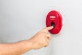 Hand with finger pressing red fire alarm on the wall Royalty Free Stock Photo