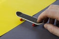 Hand and finger skateboard on gray-yellow background Royalty Free Stock Photo