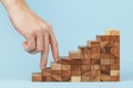 Hand finger walk on stacked wooden block like stairs.