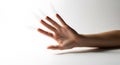 A hand reaching out with fingers spread against a plain white background in a studio setting Royalty Free Stock Photo