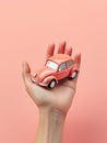 A hand firmly holds a toy car against a neutral background