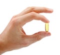 Hand with fish oil capsule isolated on white Royalty Free Stock Photo