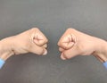 Hand fist opposite of another male hand fist wearing blue shirt, corporate opposition Concept, black background