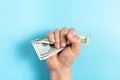 A hand in a fist squeezing cash money hundred dollar bills Royalty Free Stock Photo