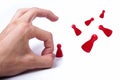 Hand flicking away small red game pieces