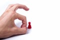 Hand flicking a single red game piece on white background, elimination Royalty Free Stock Photo