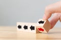 Hand flip over wooden cube block with red arrow facing the opposite direction black arrows Royalty Free Stock Photo