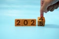 Hand flipping block 2024 to 2025 text on table