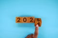 Hand flipping block 2024 to 2025 text on table