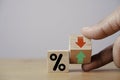 Hand flipping wooden cube block to change between up and down with percentage sign symbol for increase and decrease financial