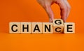 Hand flips a cube and changes the word `change` to `chance`. Beautiful orange background, copy space. Business concept Royalty Free Stock Photo