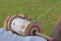 Hand flying kite holding thread on a grassland