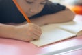 Hand focusing of adorable asian child girl is writing and reading on her paper book in the room at home with sunlight shows Royalty Free Stock Photo