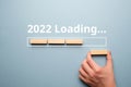Hand folds from wooden blocks concept of loading new year 2022