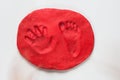 Hand and foot print of child made on red dry doug Royalty Free Stock Photo