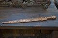 Hand forged pirate cutlass with copper guard on a wooden background