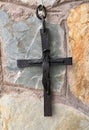 Hand forged rustic iron wall cross, cast in stone wall Royalty Free Stock Photo