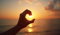 Hand framing sun over ocean at sunset Royalty Free Stock Photo