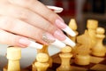 Hand with french manicure playing chess