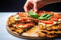 hand a freshly baked cauliflower pizza into slices Royalty Free Stock Photo