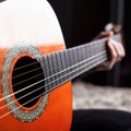 Hand on fretboard acoustic guitar norange color