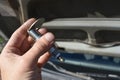 Hand Gapping a Spark Plug in Front of Car