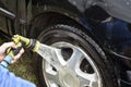 Hand with the garden hose tip flushes with aluminum rim Royalty Free Stock Photo