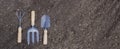 Hand garden tools on black fertile soil. Preparation for planting seedlings. Banner panorama Royalty Free Stock Photo