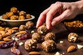 hand garnishing date and nut balls with dried fruit pieces
