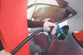 Hand of gas station attendant holding a fuel petrol pump nozzle against for filling up the car with petrol at gas station Royalty Free Stock Photo