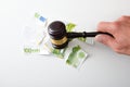 Hand with gavel breaking bank note financial judgment concept Royalty Free Stock Photo