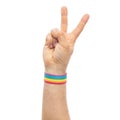 Hand with gay pride rainbow wristband make peace