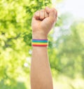 Hand with gay pride rainbow wristband shows fist