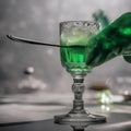 A hand gently dropping a sugar cube into a glass of absinthe with an ornate spoon2