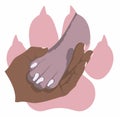 The hand gently holds a dog`s paw on the background of the imprint of a pink dog`s paw. Symbol of love for dogs. Animal protecti