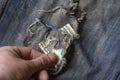 Hand gently pulls American Dollars out of ripped jeans