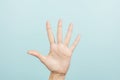 Hand gesture. Female hand shows number five. Woman hand pointing up with three fingers on light blue background Royalty Free Stock Photo