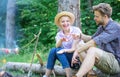 Hand gesture game decide who win. Winner eats first. Couple tourists throwing their gesture while sit log near bonfire Royalty Free Stock Photo