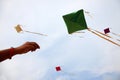 Hand of a girl raises a kite in a sky