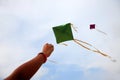 Hand of a girl raises a kite in a sky