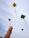 Hand of a girl raises a kite in a sky
