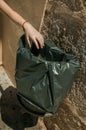 Hand of girl throwing waste in a trash can at Merida