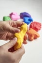 The hand of a girl who sculpts from light airy multi-colored plasticine