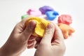 The hand of a girl who sculpts from light airy multi-colored plasticine