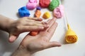 The hand of a girl who sculpts roses from light airy multi-colored plasticine