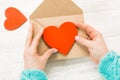 Hand of girl writing love letter on Saint Valentines Day. Handmade postcard with red heart shaped figure. 14 February holiday Royalty Free Stock Photo